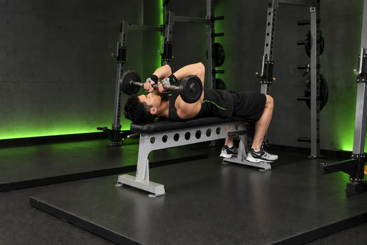 Đẩy tay sau nằm ngửa với thanh EZ tay hẹp, hạ về cằm (Kết thúc)