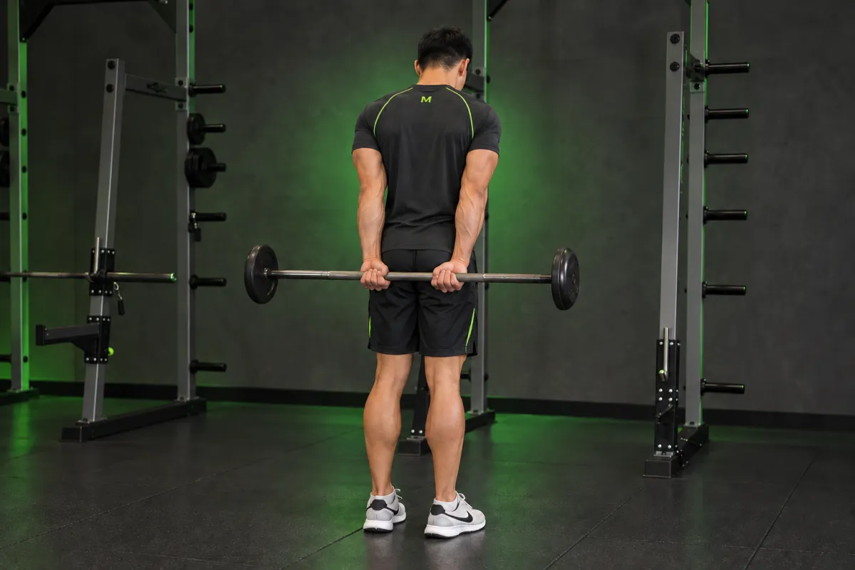 Standing Palms-Up Barbell Behind The Back Wrist Curl (End)